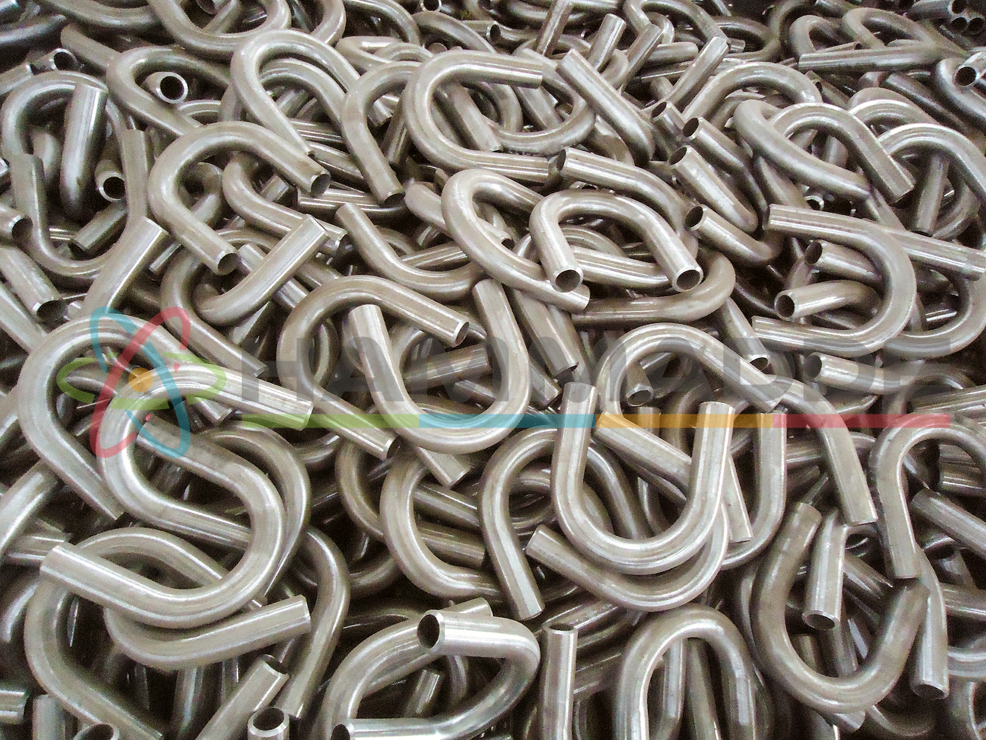 Industrial abstract background. Products of bent steel pipes in heap / Increased noise and grain.